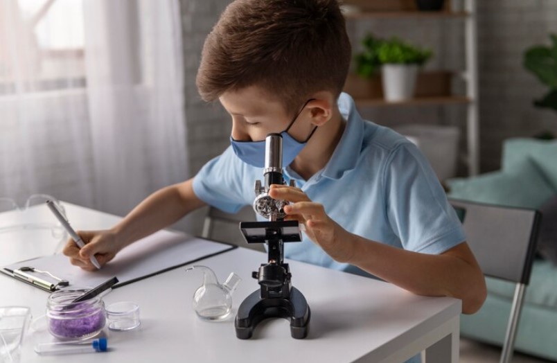 Student in mask and use microscope